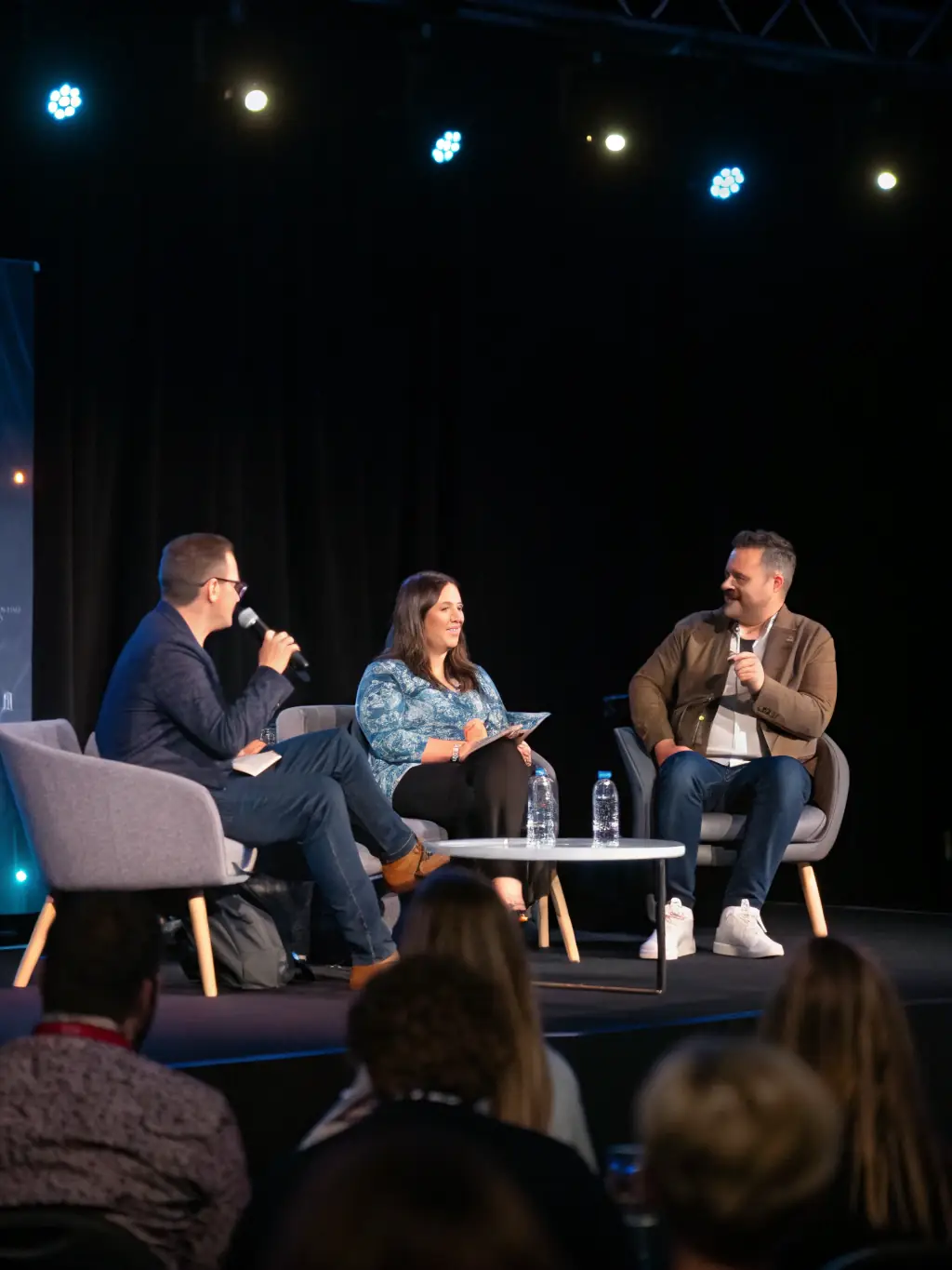 A professional photograph of a panel discussion at a marketing conference, featuring industry experts sharing their insights and experiences.